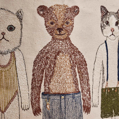 Coral and Tusk's "Pocket Doll" canvas bucket bag featuring embroidered designs of animal friends in fanciful clothing