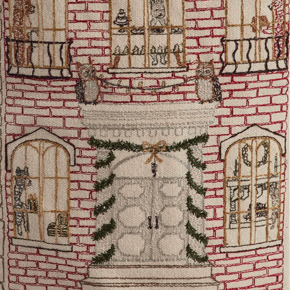 Coral and Tusk's "Home For the Holidays" embroidered canvas bucket featuring intricate designs of woodland friends decorating their city home