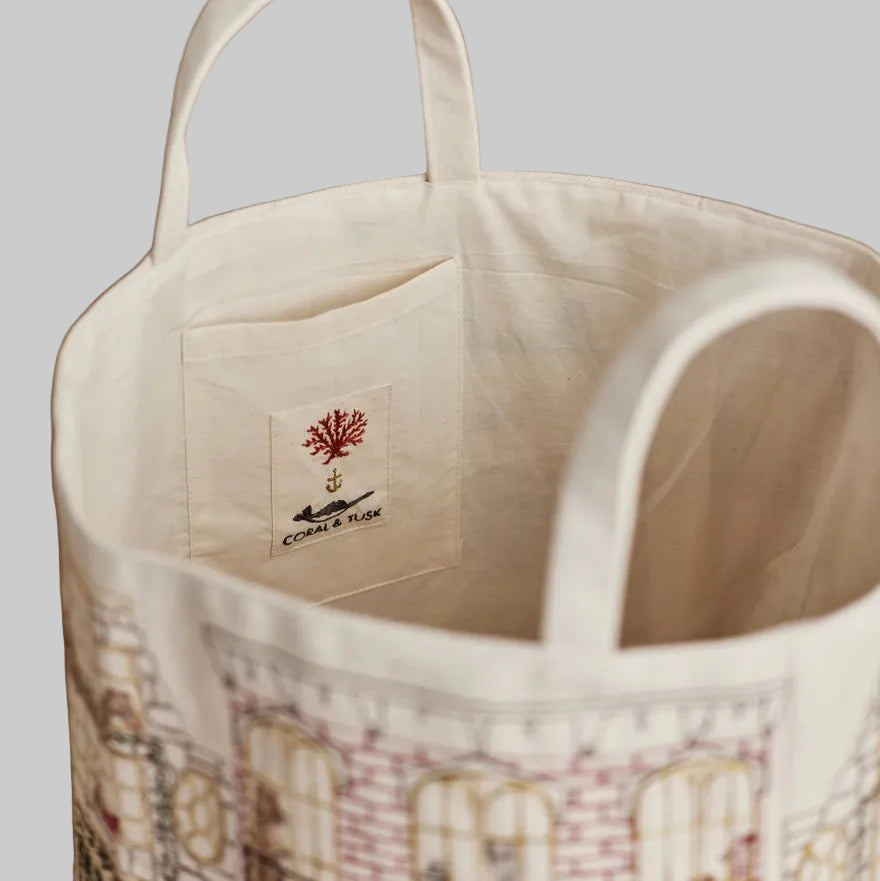 Coral and Tusk's "Home For the Holidays" embroidered canvas bucket featuring intricate designs of woodland friends decorating their city home