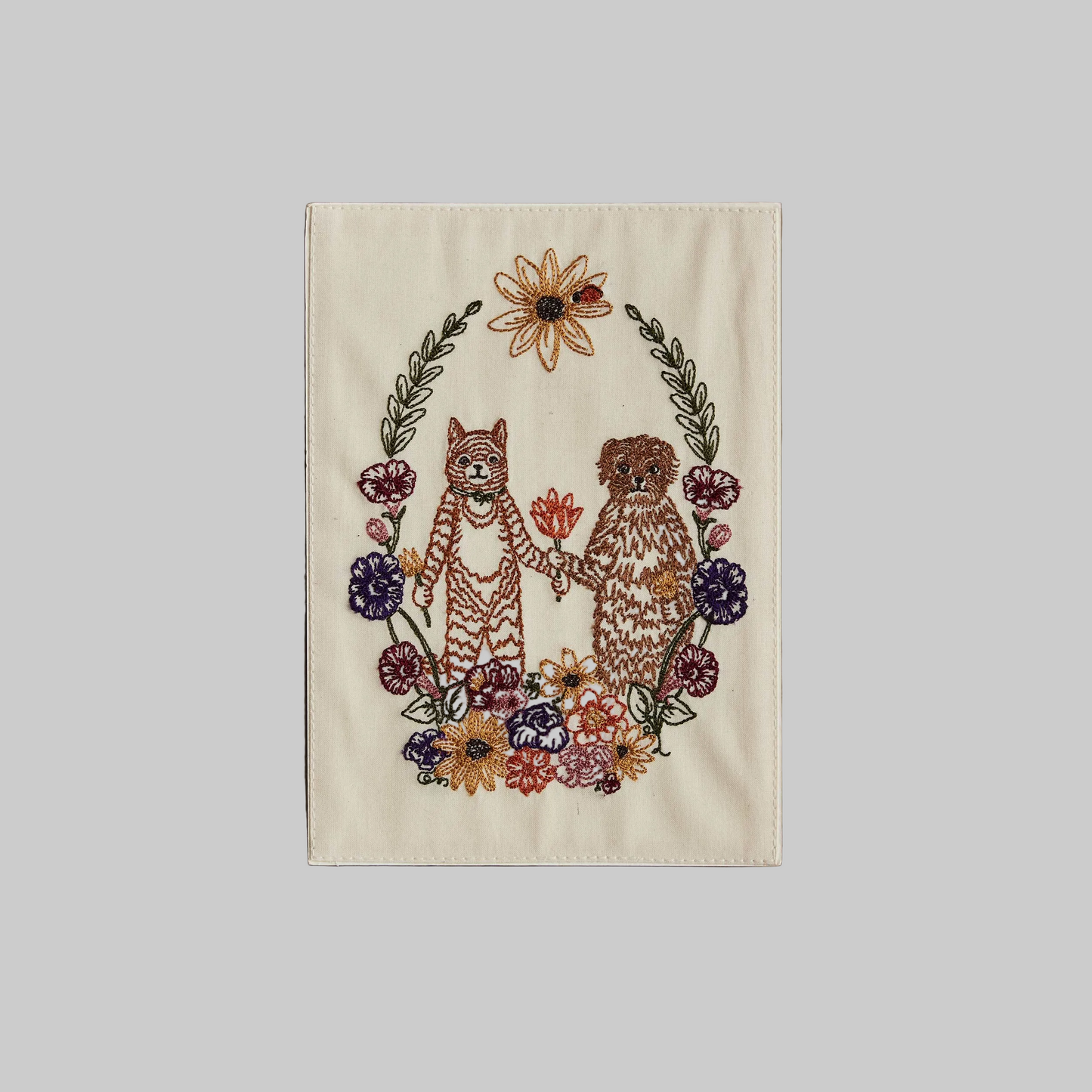 Coral and Tusk's "Cat and Dog Friends" embroidered keepsake card  featuring a cat and dog surrounded by a wreath of flowers
