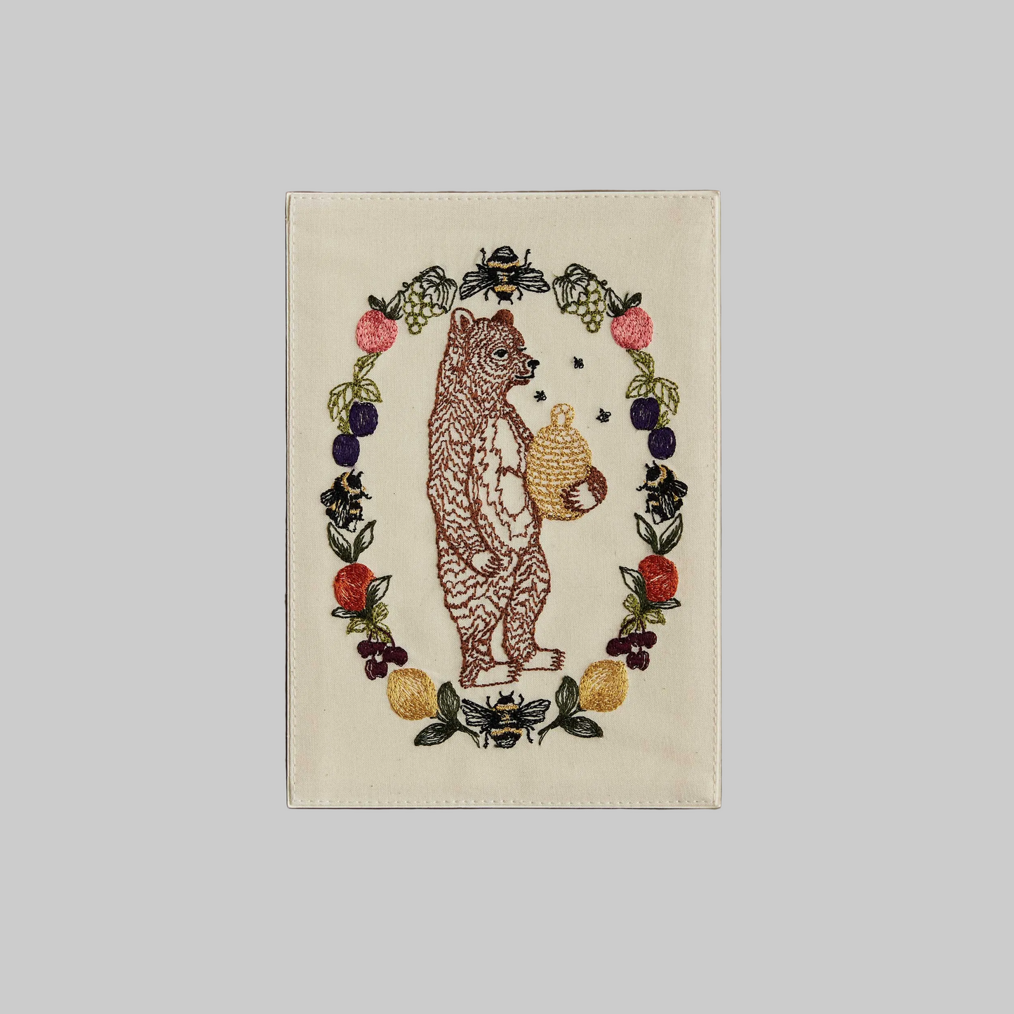 Coral and Tusk's "Honey Bear" embroidered keepsake card  featuring a bear holding a beehive surrounded by a wreath of fruits
