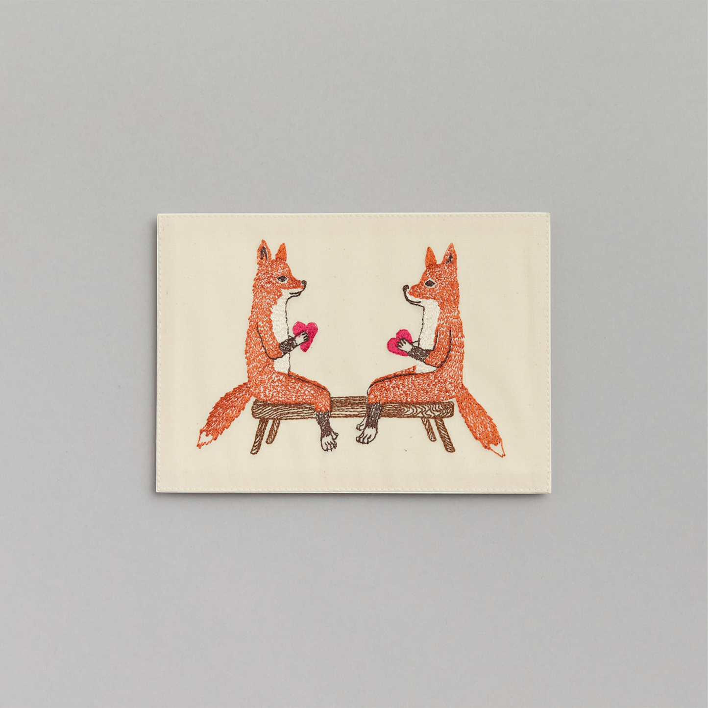 Coral and Tusk's "Smitten Foxes" embroidered keepsake card  featuring two foxes holding hearts