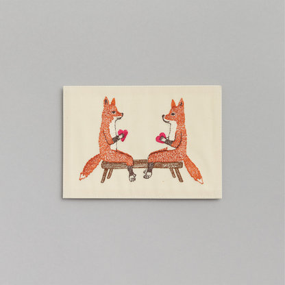 Coral and Tusk's "Smitten Foxes" embroidered keepsake card  featuring two foxes holding hearts
