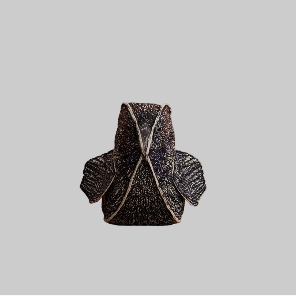 Coral and Tusk's Blackbird of Mystery keepsake object featuring detailed embroidery in black, indigo, violet, and maroon