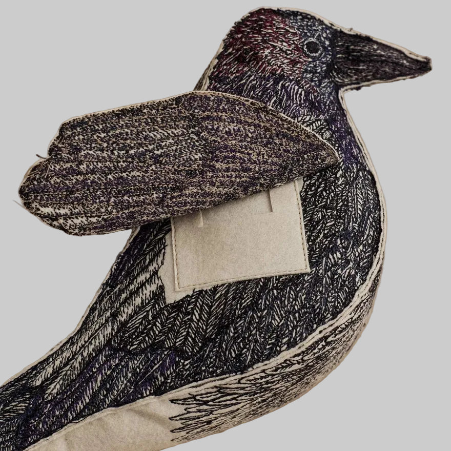 Coral and Tusk's Blackbird of Mystery keepsake object featuring detailed embroidery in black, indigo, violet, and maroon