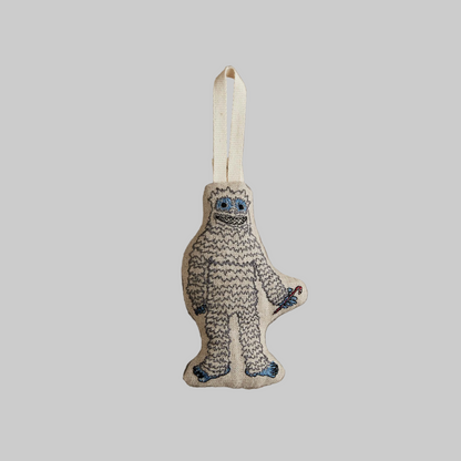 Coral and Tusk's "Yeti with Candy Cane" embroidered linen Christmas ornament featuring design of a smell white yeti