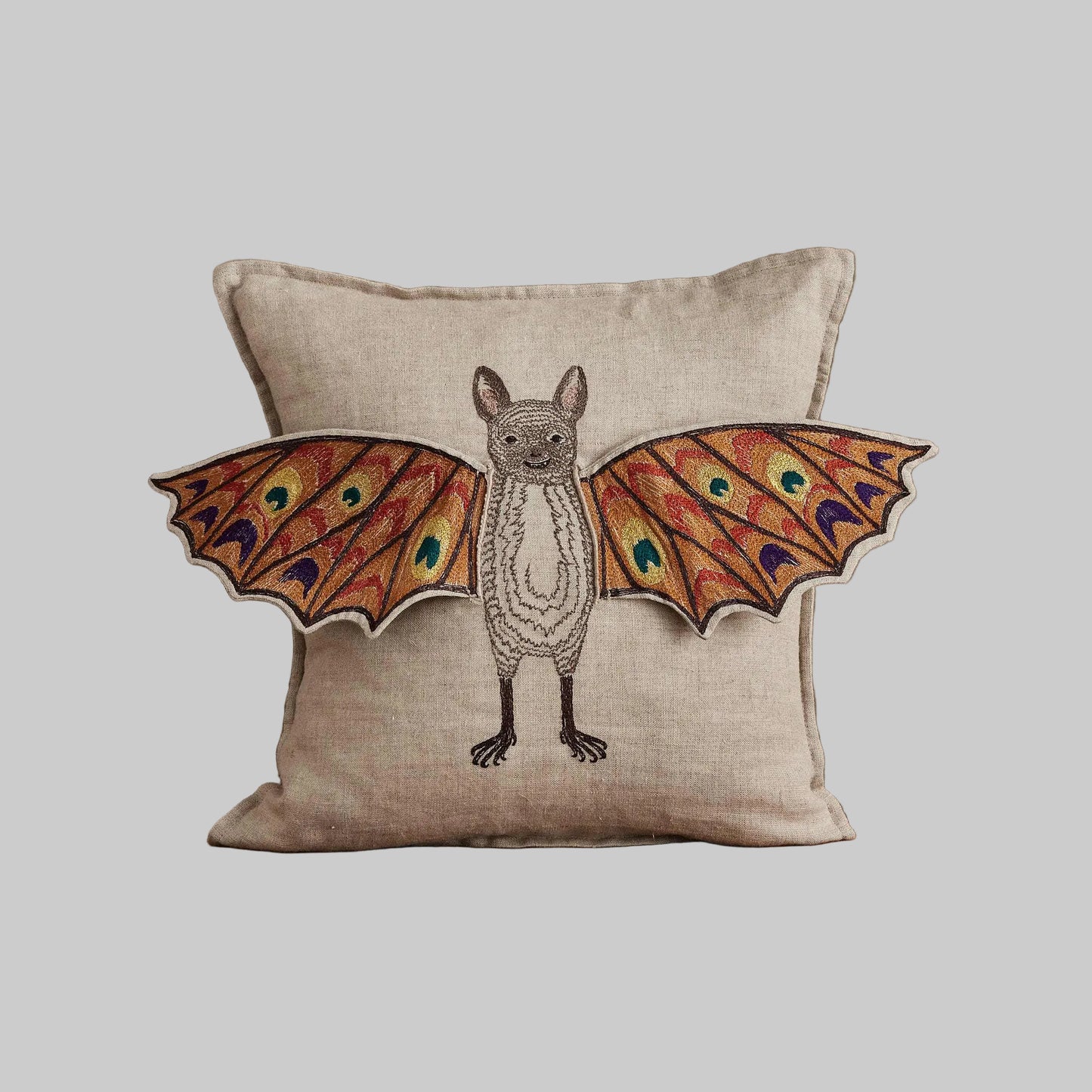 Coral and Tusk’s “Bat Wing Surprise” embroidered linen pillow featuring a bat with wings that open up to reveal the design of a butterfly, measures 12x12