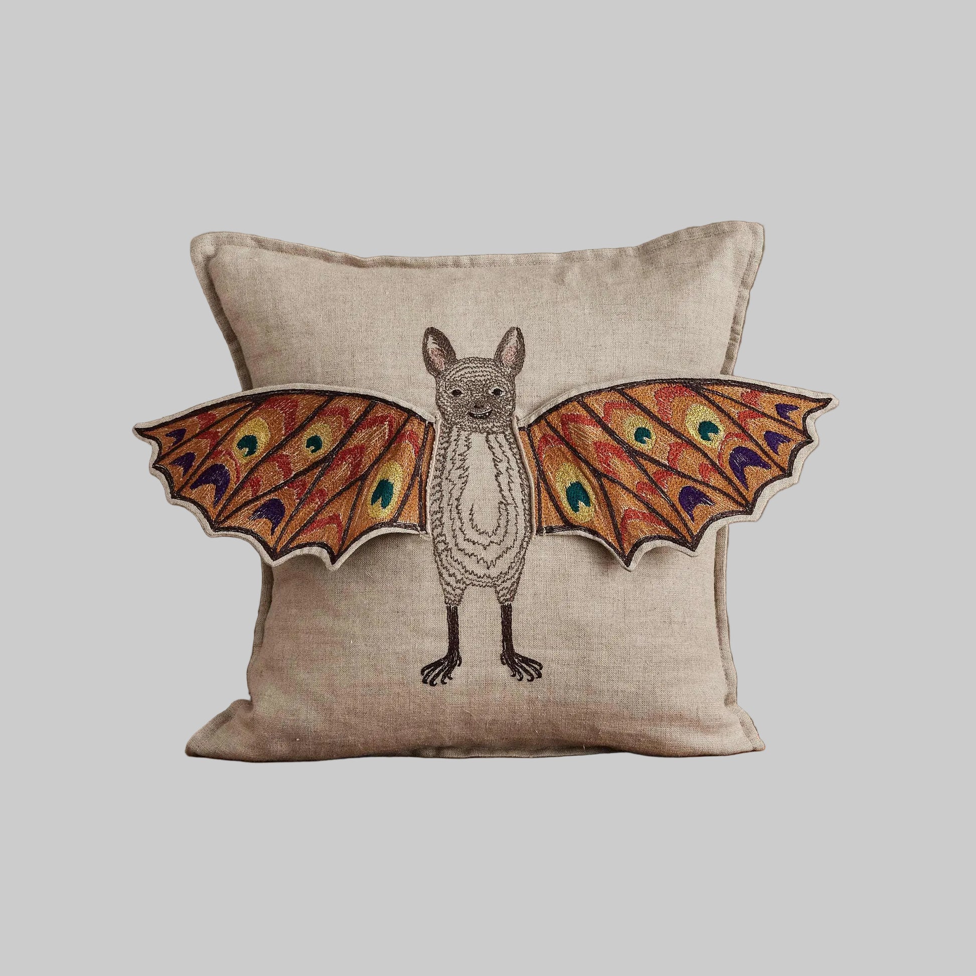 Coral and Tusk’s “Bat Wing Surprise” embroidered linen pillow featuring a bat with wings that open up to reveal the design of a butterfly, measures 12x12