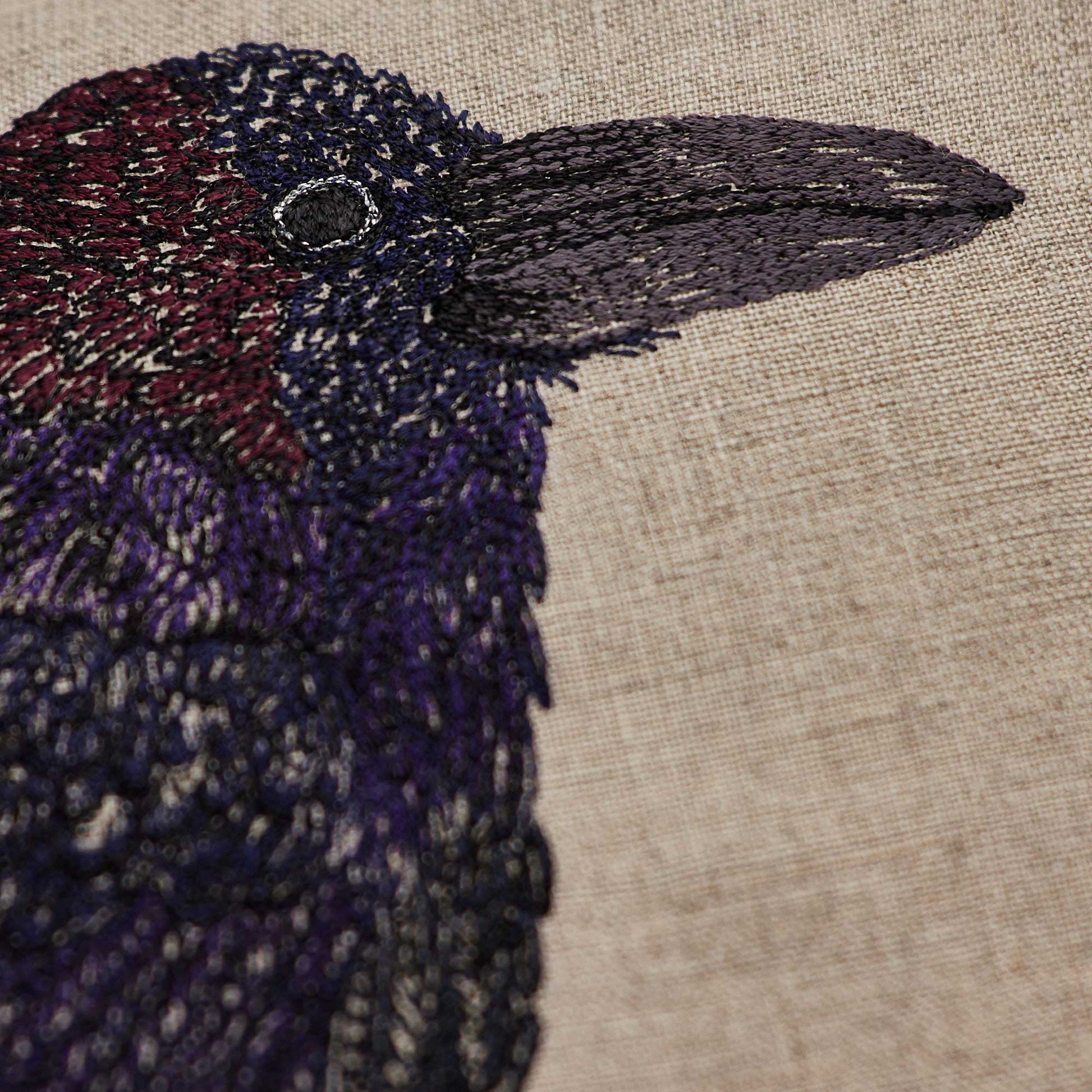 Coral and Tusk’s “Blackbird with Acorn” embroidered linen pillow featuring a blackbird holding an acorn in its claw, measures 12” x 16”