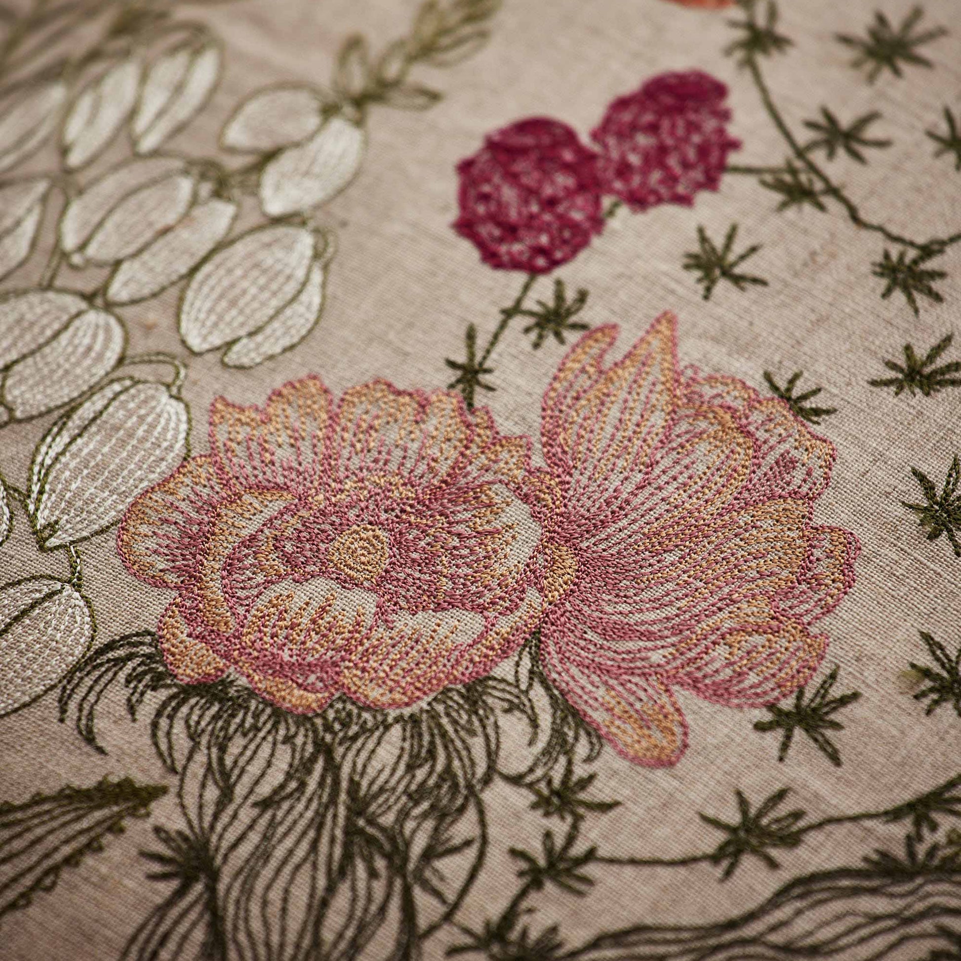 Coral and Tusk’s “Desert Blooms” embroidered linen pillow featuring vibrant colors of flowering cactus and blossoming agave, measures 20” x 20”