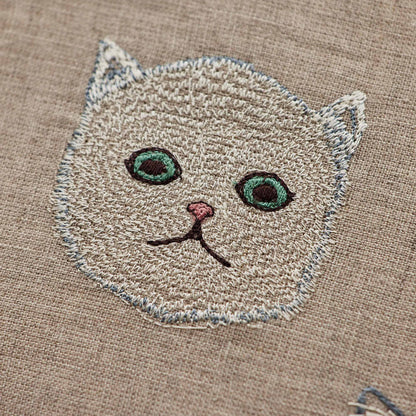 Coral and Tusk’s “Charming Cats” embroidered linen pillow featuring five cats and their lucky charms, measures 12” x 12”