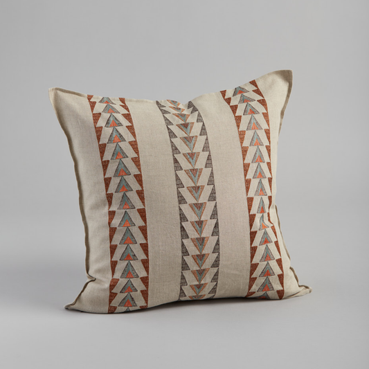 Coral and Tusk's "Cody Stripe" embroidered linen pillow featuring a geometric design with cascading triangles in sky blue, umber and vermilion, measures 20" x 20"