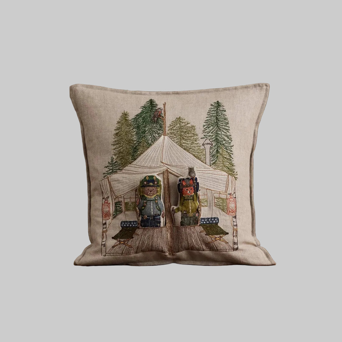 Coral and Tusk's embroidered linen "Explorers" pocket pillow featuring designs of a fox and bear in a glamping tent