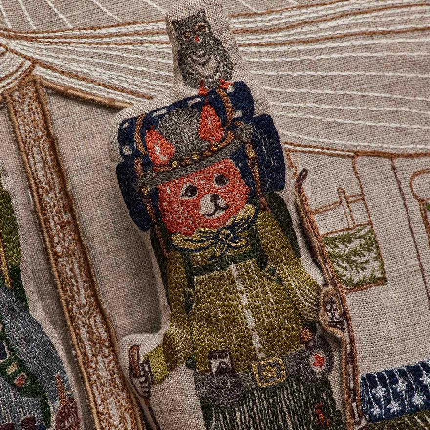 Coral and Tusk's embroidered linen "Explorers" pocket pillow featuring designs of a fox and bear in a glamping tent