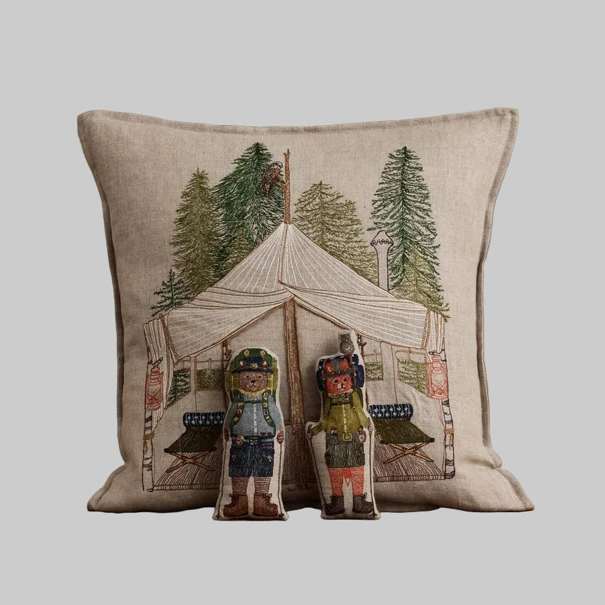 Coral and Tusk's embroidered linen "Explorers" pocket pillow featuring designs of a fox and bear in a glamping tent