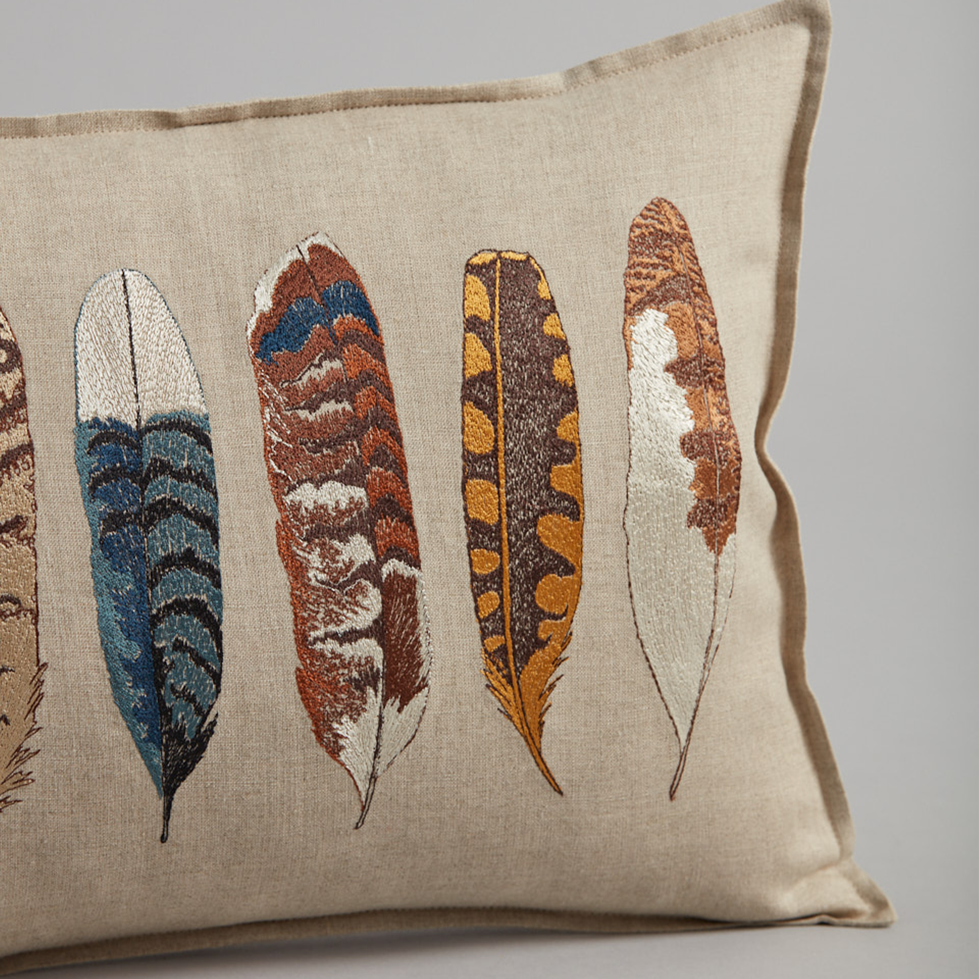 Coral and Tusk’s “Medium Feathers” embroidered linen pillow featuring a variety of bird feathers, measures 12” x 16”