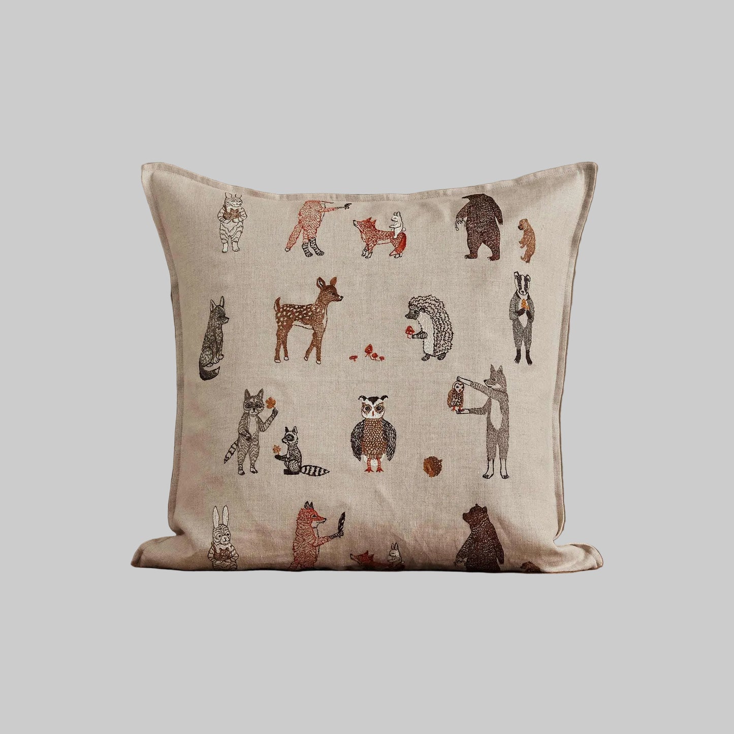 Coral and Tusk’s “Woodland Friends” embroidered linen pillow featuring woodland creature pals and their foraged finds, measures 20” x 20”