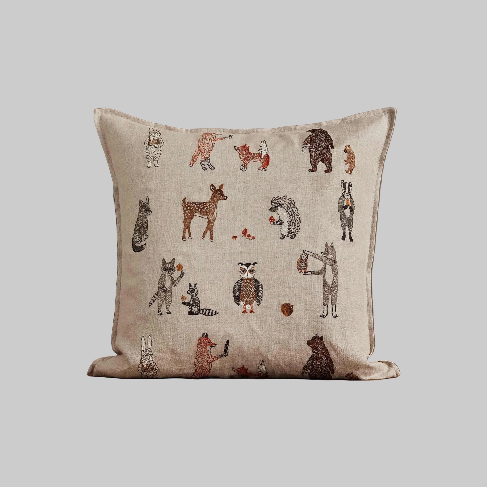 Coral and Tusk’s “Woodland Friends” embroidered linen pillow featuring woodland creature pals and their foraged finds, measures 20” x 20”