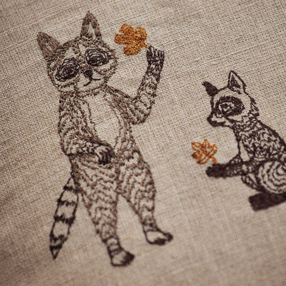 Coral and Tusk’s “Woodland Friends” embroidered linen pillow featuring woodland creature pals and their foraged finds, measures 20” x 20”