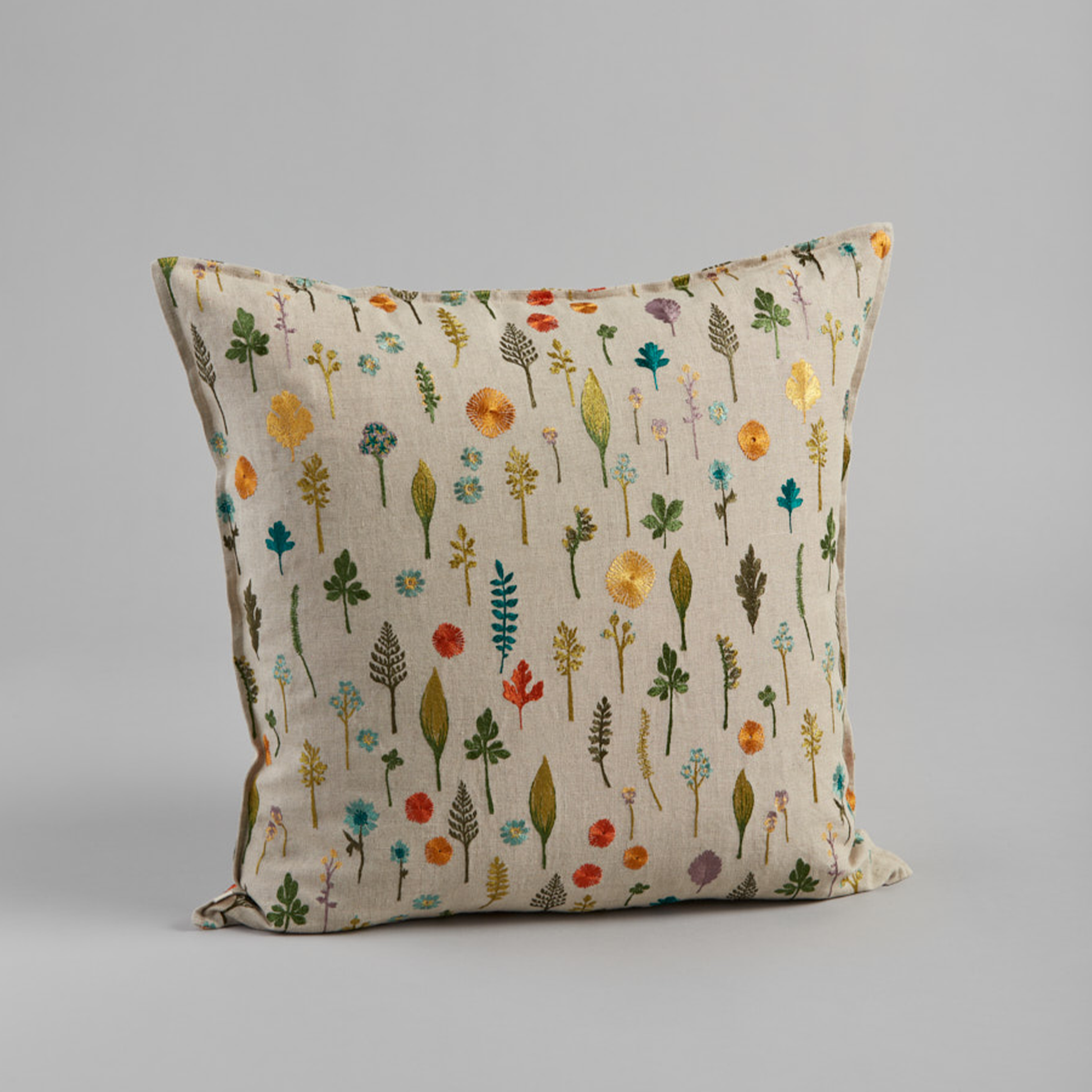 Coral and Tusk's "Garden Pattern" embroidered linen pillow featuring a field of dandy flowers, forget-me-nots, violets and sprigs, measures 20" x 20"