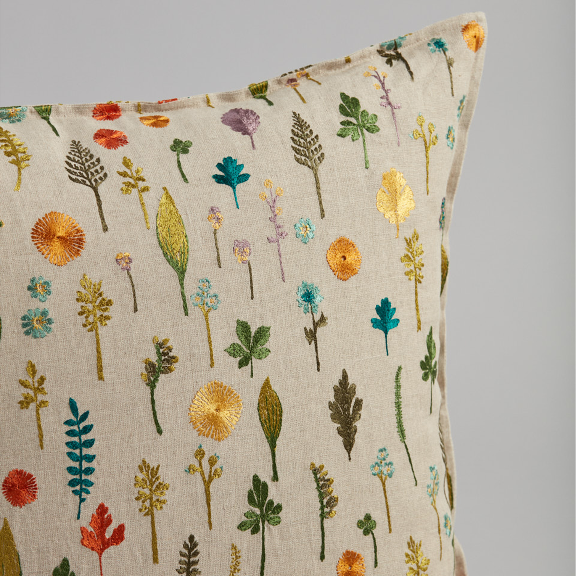 Coral and Tusk's "Garden Pattern" embroidered linen pillow featuring a field of dandy flowers, forget-me-nots, violets and sprigs, measures 20" x 20"