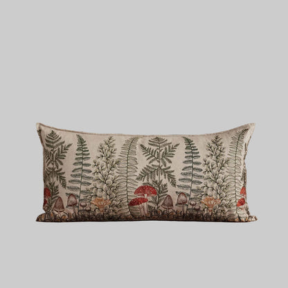 Coral and Tusk’s “Mushrooms and Ferns” embroidered linen lumbar pillow featuring a shade garden of ferns intertwined with a treasure trove of mushrooms, measures 16” x 32”