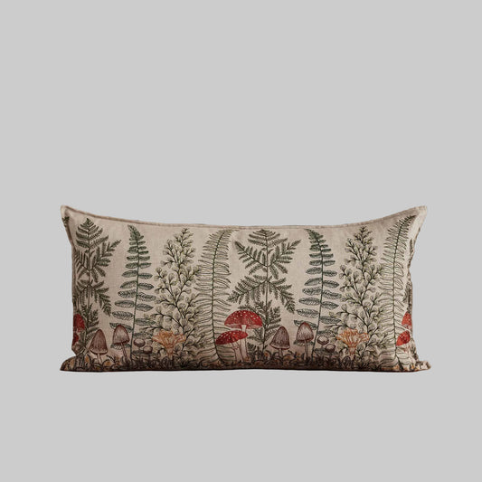 Coral and Tusk’s “Mushrooms and Ferns” embroidered linen lumbar pillow featuring a shade garden of ferns intertwined with a treasure trove of mushrooms, measures 16” x 32”