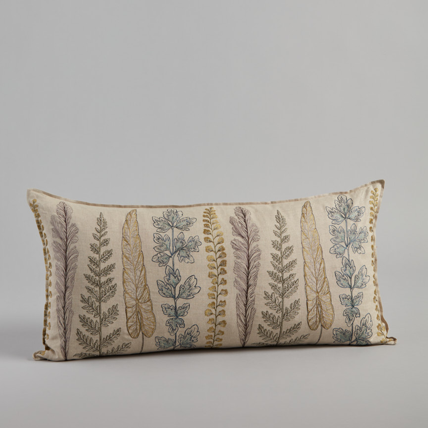 Coral and Tusk’s “Plants” embroidered linen lumbar pillow featuring a variety of plant stems in shades of green, measures 16” x 32”