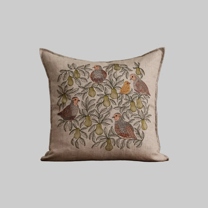 Coral and Tusk's "Partridge in A Pear Tree" embroidered linen pillow featuring a design of four partridges plus a chick perched in pear tree branches