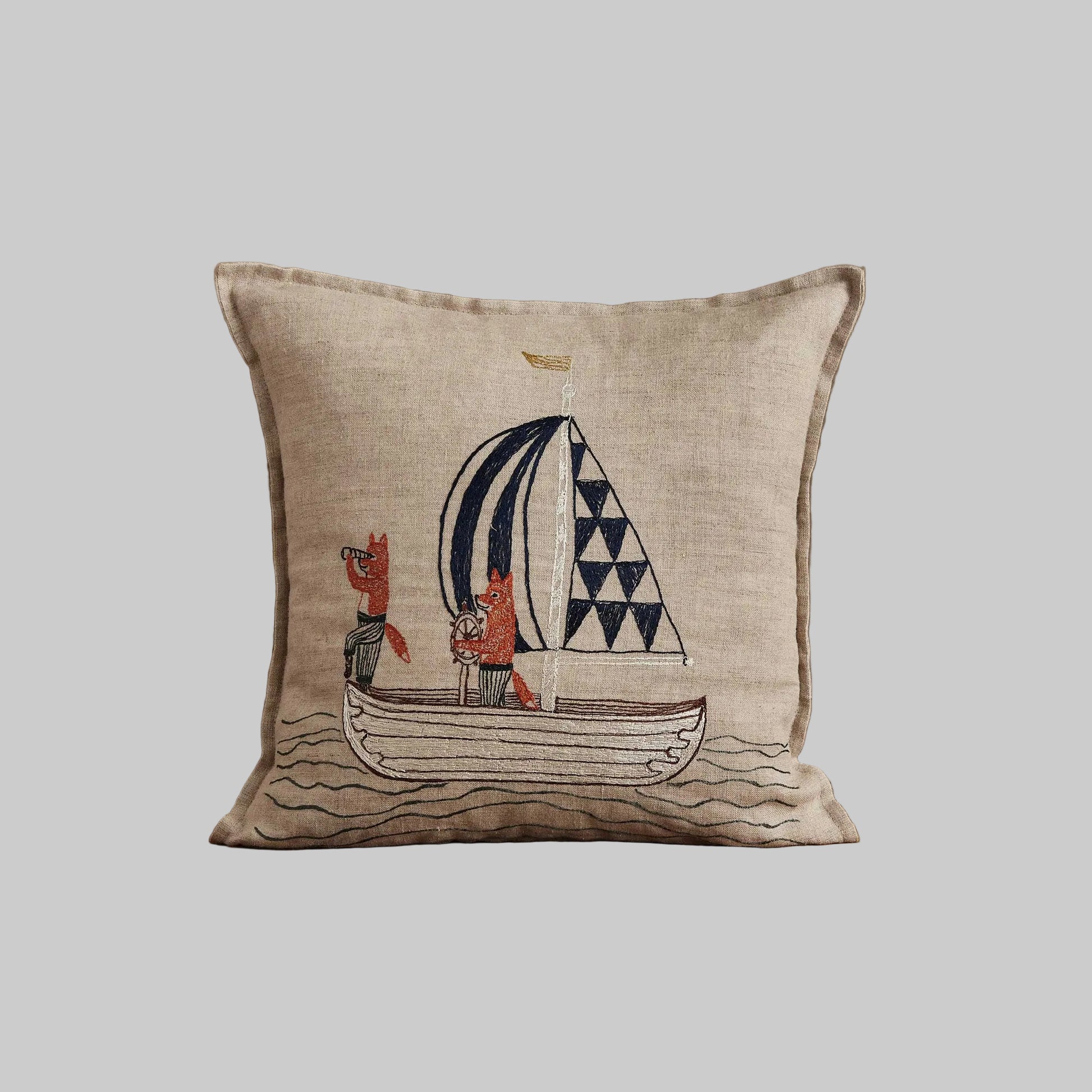 Coral and Tusk’s “Sailing Foxes” embroidered linen pillow featuring two foxes on a sailboat, measures 12” x 12”