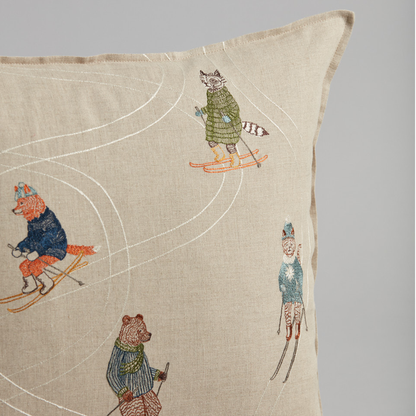 Coral and Tusk's "Downhill Skiers" embroidered linen pillow featuring five fun friends in colorful coats zipping down an alpine slope, measures 20" x 20"