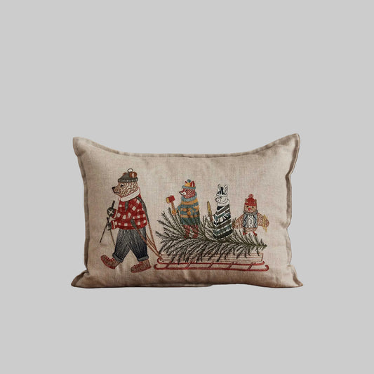 Coral and Tusk’s “Christmas Tree Sled” embroidered linen pillow featuring animal friends venturing out to cut down a pine tree, measures 12” x 16”