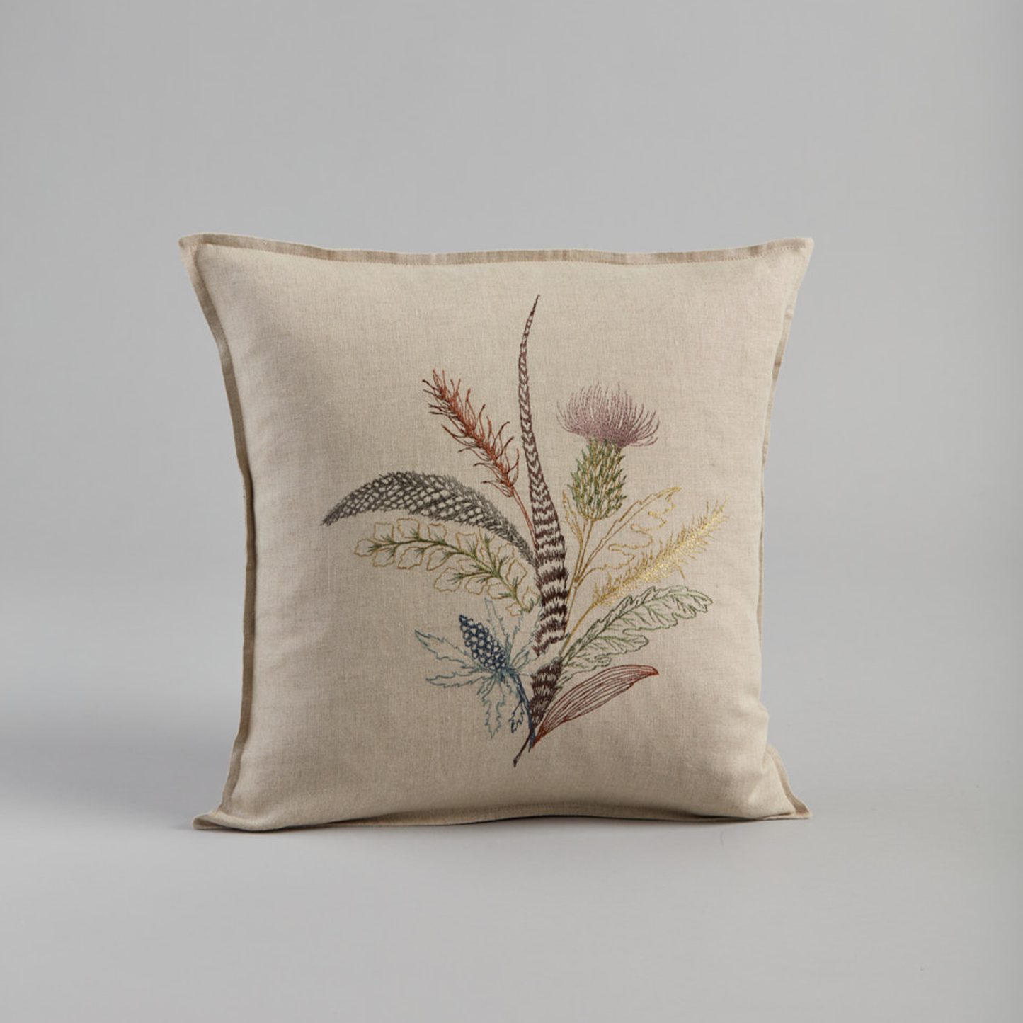 Coral and Tusk's "Thistle" embroidered linen pillow featuring a bouquet of gathered thistles, greenery and feathers, measures 16" x 16"