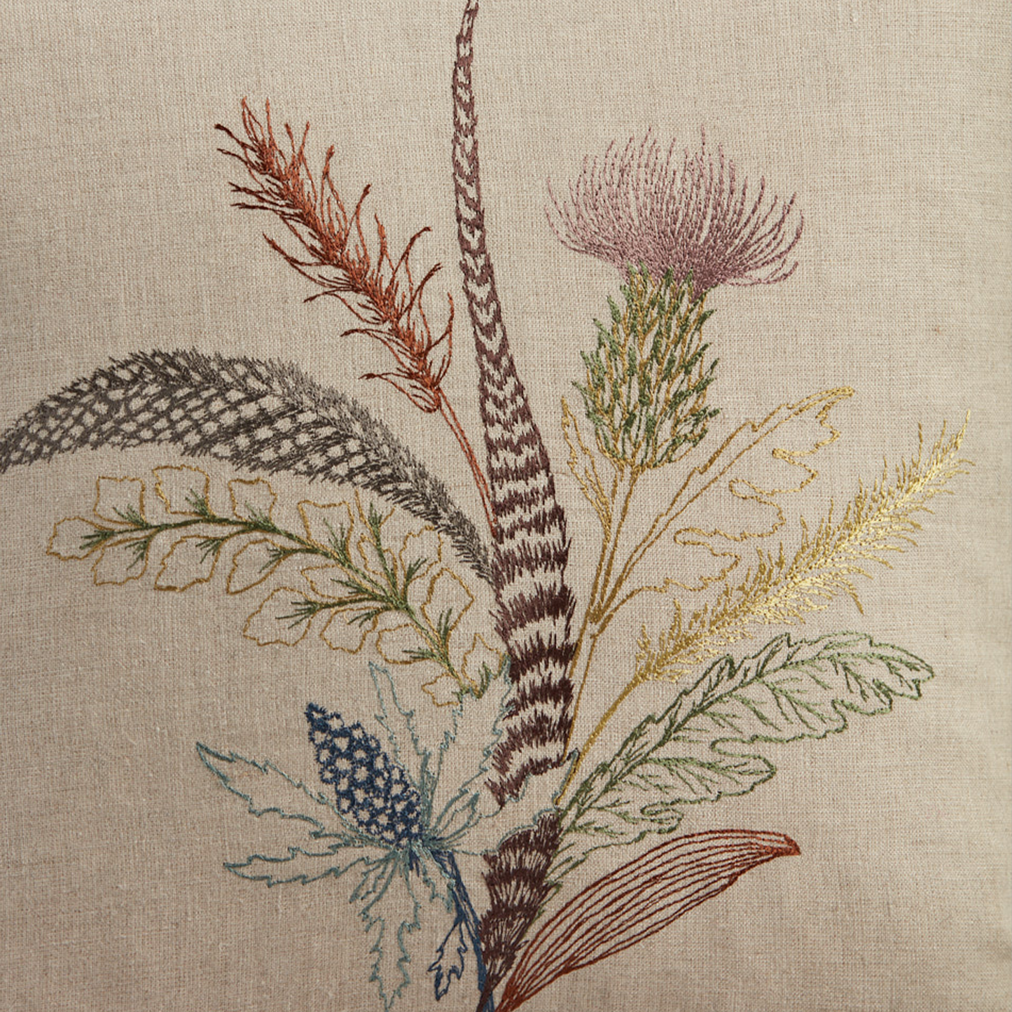 Coral and Tusk's "Thistle" embroidered linen pillow featuring a bouquet of gathered thistles, greenery and feathers, measures 16" x 16"
