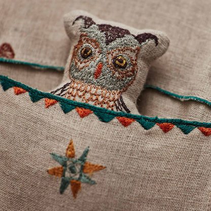 Coral and Tusk’s “Friend’s Canoe” embroidered linen pocket pillow featuring three woodland friends paddling in a canoe, measures 12” x 16”