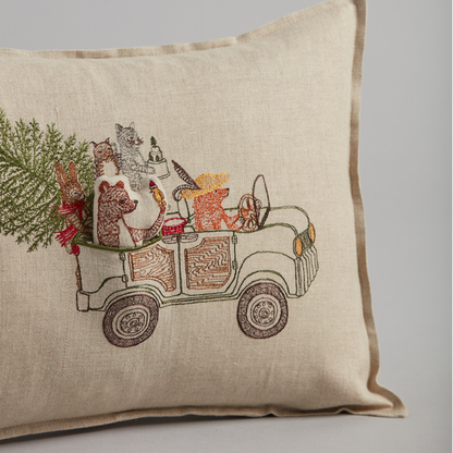Coral and Tusk's "Christmas Tree Car" embroidered linen pocket pillow featuring woodland animals riding in a car with their Christmas tree, measures 12" x 16"