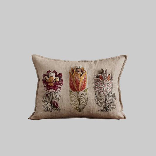 Coral and Tusk’s “Flower Friends” embroidered linen pocket pillow featuring the first flowers of spring with some animal friends hidden in their petals, measures 12” x 16”