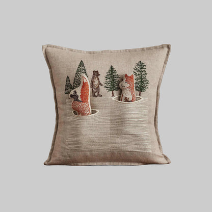 Coral and Tusk’s “Winter Foxes” embroidered linen pocket pillow featuring two foxes in the middle of a hunt, measures 12” x 12”