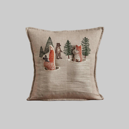 Coral and Tusk’s “Winter Foxes” embroidered linen pocket pillow featuring two foxes in the middle of a hunt, measures 12” x 12”