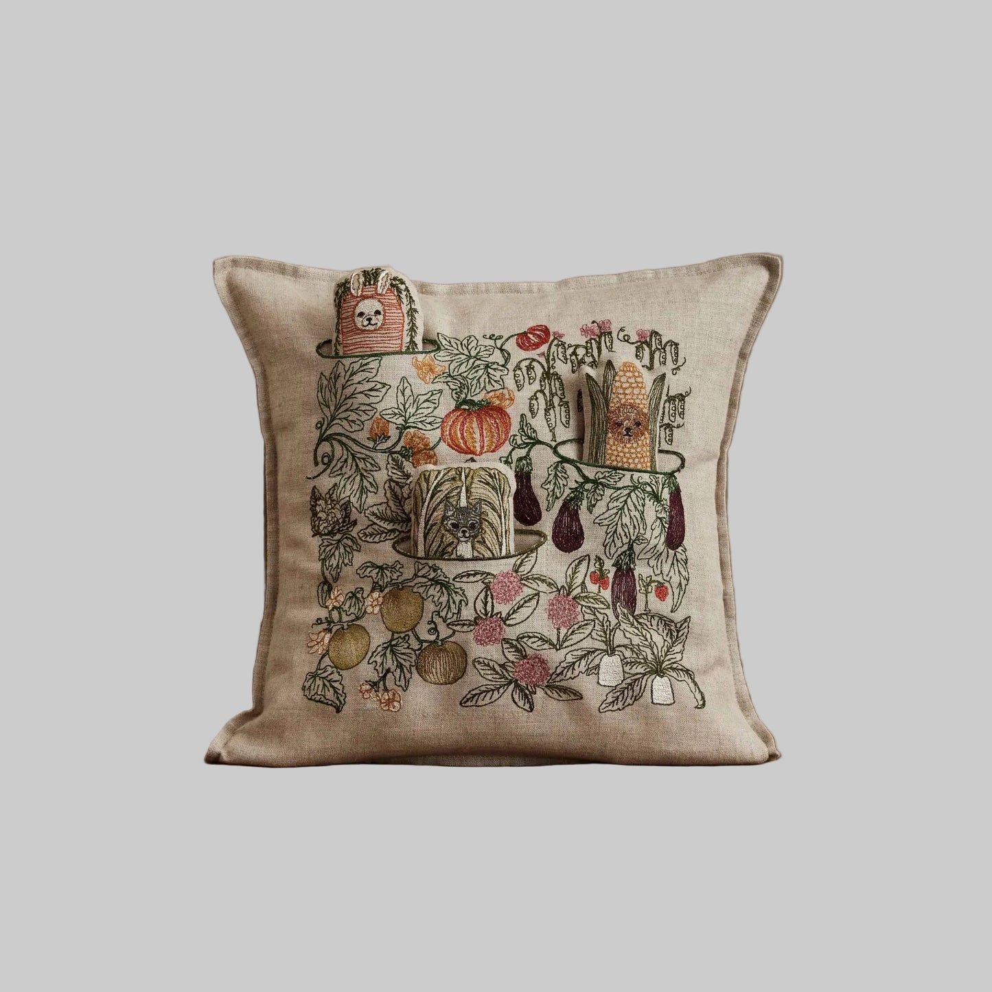 Coral and Tusk’s “Garden Patch” embroidered linen pocket pillow featuring a vegetable garden scene with three removable pals