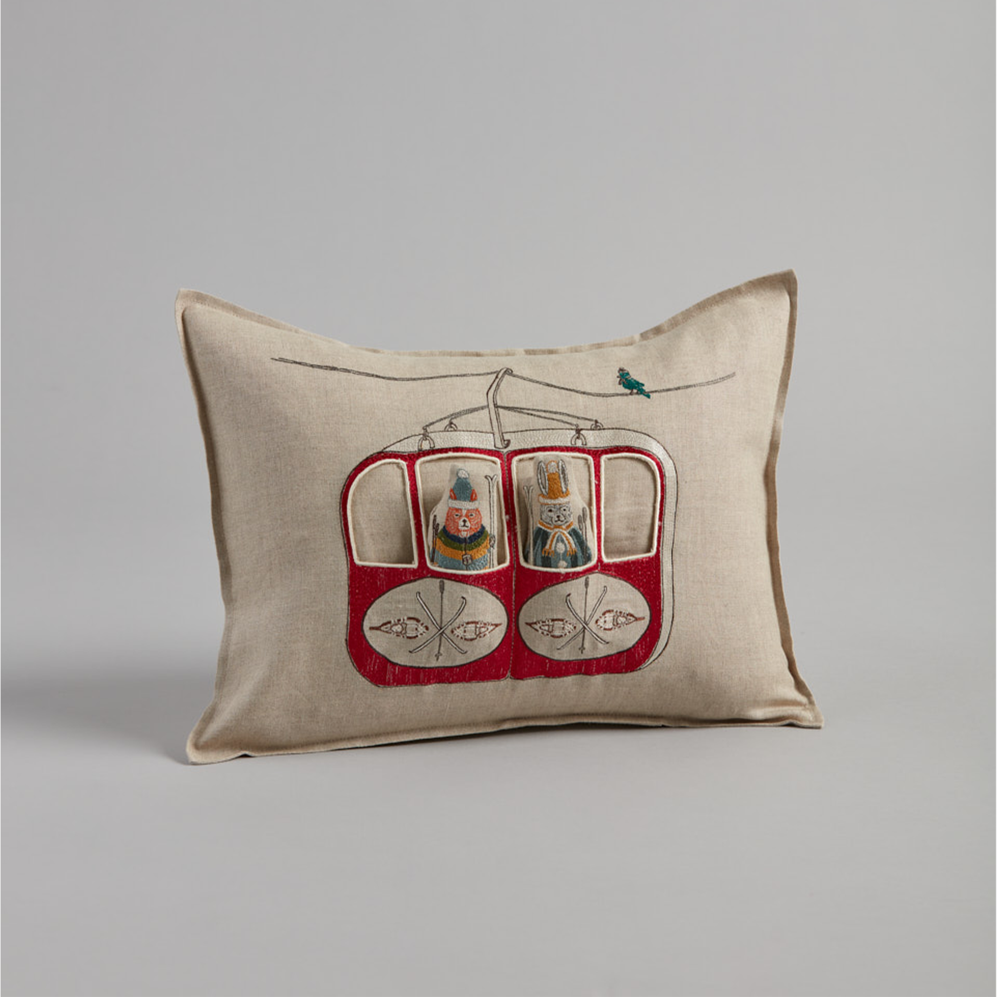 Coral and Tusk's "Gondola Ski Lift" embroidered linen pocket pillow featuring fox and bunny in their vintage ski gear riding the gondola, measures 12" x 16"