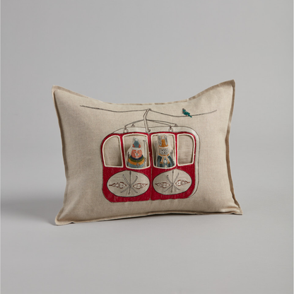 Coral and Tusk's "Gondola Ski Lift" embroidered linen pocket pillow featuring fox and bunny in their vintage ski gear riding the gondola, measures 12" x 16"