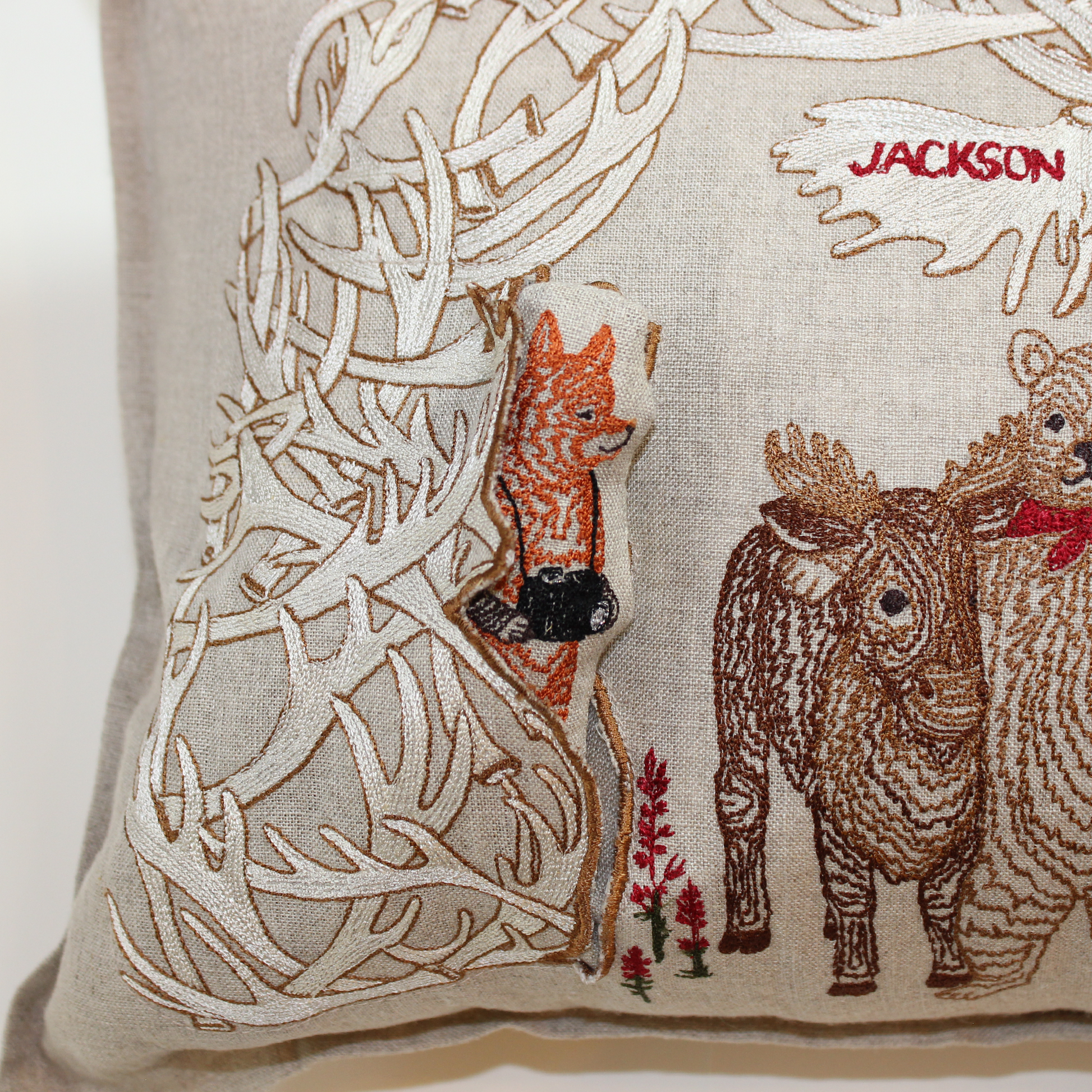 A Workshop x Coral and Tusk collaboration, this pillow features animal friends gathering for a photo under Jackson's iconic Antler Arch, measures 12" x 16"