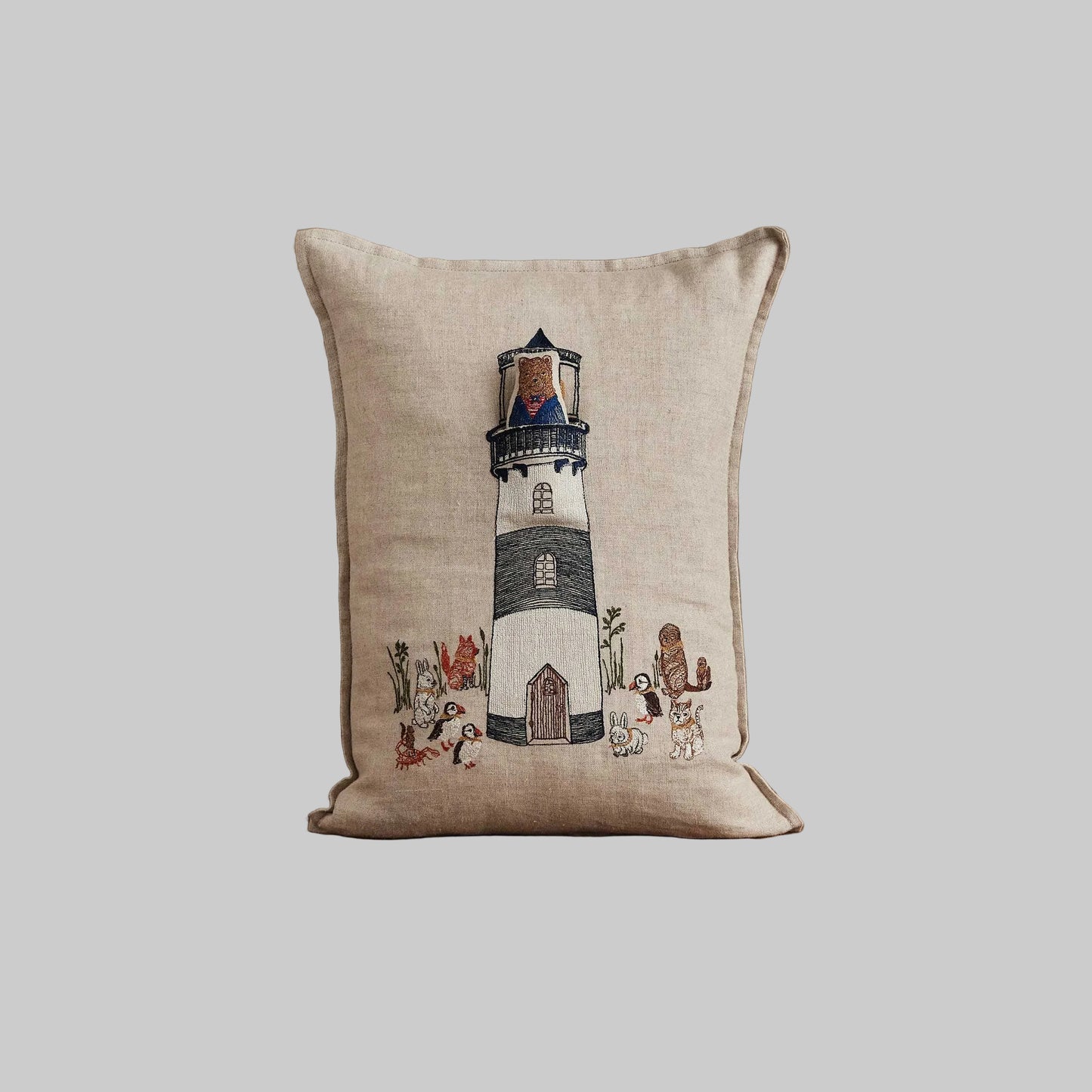 Coral and Tusk’s “Lighthouse Friends embroidered linen pocket pillow featuring a lighthouse keeper bear lighting the way for his nautical friends, measures 12” x 16”