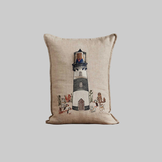 Coral and Tusk’s “Lighthouse Friends embroidered linen pocket pillow featuring a lighthouse keeper bear lighting the way for his nautical friends, measures 12” x 16”