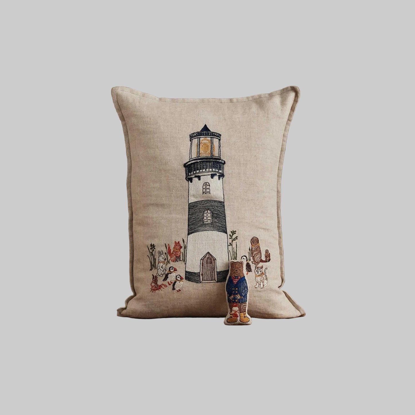 Coral and Tusk’s “Lighthouse Friends embroidered linen pocket pillow featuring a lighthouse keeper bear lighting the way for his nautical friends, measures 12” x 16”