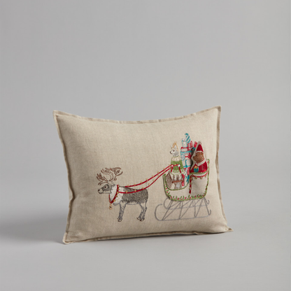 Coral and Tusk's "Santa's Sleigh" embroidered linen pocket pillow featuring Ms. Claus taking the reins with a sleigh full of presents, measures 12" x 16"