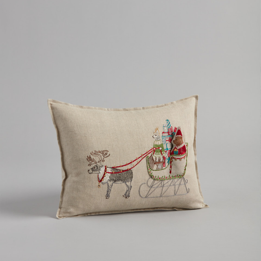 Coral and Tusk's "Santa's Sleigh" embroidered linen pocket pillow featuring Ms. Claus taking the reins with a sleigh full of presents, measures 12" x 16"