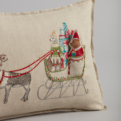 Coral and Tusk's "Santa's Sleigh" embroidered linen pocket pillow featuring Ms. Claus taking the reins with a sleigh full of presents, measures 12" x 16"