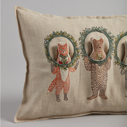 Coral and Tusk's "Christmas Wreath Trio" embroidered linen pocket pillow featuring  three woodland friends celebrating the holiday season with Christmas wreaths, measures 12" x 16"